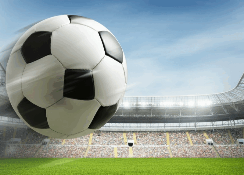 Pallone da calcio in volo verso la porta di un campo da calcio, simbolo di emozione e quote Coppa Italia.
