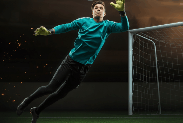 Portiere in azione con guanti da calcio che para un pallone davanti alla porta - Guida completa portieri fantacalcio 2025