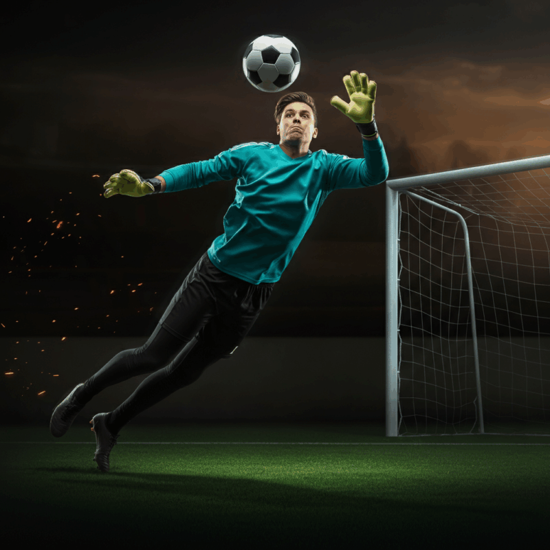 Portiere in azione con guanti da calcio che para un pallone davanti alla porta - Guida completa portieri fantacalcio 2025