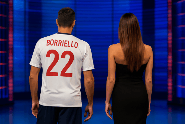 Belen e Borriello di spalle in uno studio televisivo, lui con maglia da calciatore, lei in abito elegante.