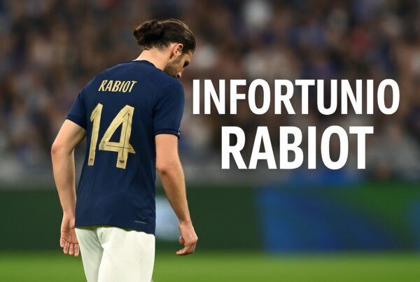 Adrien Rabiot fotografato di spalle con la maglia blu numero 14 della nazionale, mentre cammina a testa bassa fuori dal campo dopo un infortunio, con la scritta INFORTUNIO RABIOT centrata a destra
