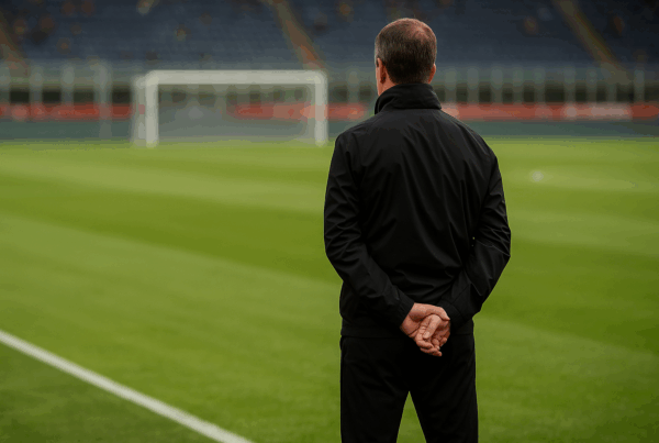 Allenatore non riconoscibile di spalle su un campo da calcio italiano al tramonto, simbolo del Successore di Tudor e della rinascita della Juventus.