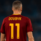 Artem Dovbyk di spalle con la maglia rossa della Roma allo Stadio Olimpico, immagine dedicata all’articolo sull’Infortunio per Dovbyk.