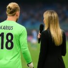 Loris Karius di spalle in divisa da portiere accanto a Diletta Leotta con un microfono in mano su un campo da calcio illuminato, simbolo del connubio tra sport e spettacolo raccontato nell’articolo Chi è Loris Karius.