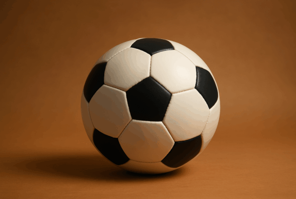 Oggetti storici che mostrano visivamente dove è nato il calcio: pallone moderno, pallone vintage e vaso greco.