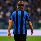 Immagine giocatore Atalanta visto di spalle con maglia nerazzurra durante una partita di calcio, in un campo affollato di tifosi riferita a dove gioca Daniel Maldini