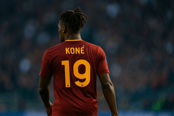 Infortunio di Manu Koné, immagine del giocatore di spalle in maglia numero 19 della Roma durante una partita, formato 16:9.