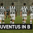 Giocatori di calcio con maglia bianconera camminano di spalle su un campo malandato, con la scritta bianca JUVENTUS IN SERIE B su barra nera in basso