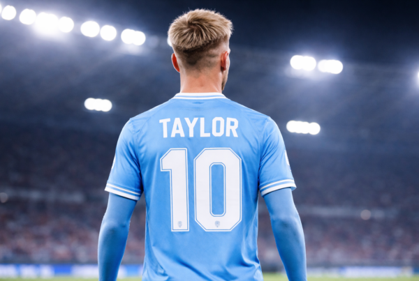 Taylor verso la Lazio, calciatore di spalle con maglia azzurra numero 10 in uno stadio illuminato