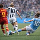 Calciatrici di spalle in azione durante una partita, dribbling e tackle in scivolata, immagine per articolo calciatrice più pagata in Italia