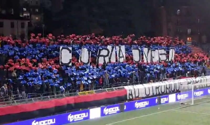 Curva del Potenza gremita di tifosi con coreografia rosso e blu e striscione “CURVA OVEST” esposto sugli spalti durante la partita Ternana Potenza Coppa Italia.