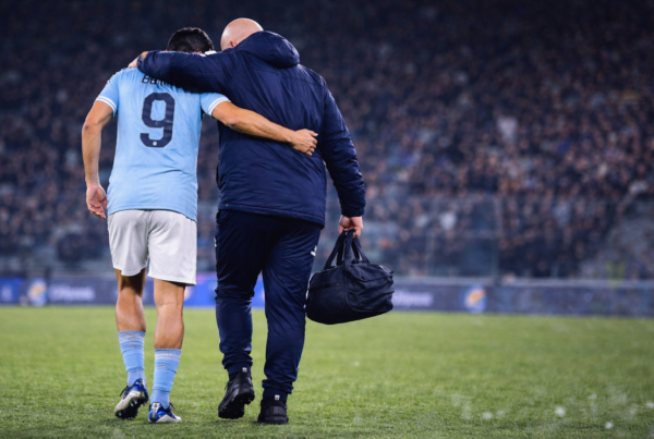 Infortunio Pedro: l’attaccante della Lazio di spalle esce dal campo sorretto dallo staff medico dopo il problema alla caviglia