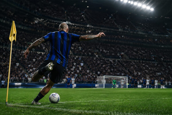 Dimarco assist record, calciatore nerazzurro di spalle batte un calcio d’angolo in uno stadio gremito