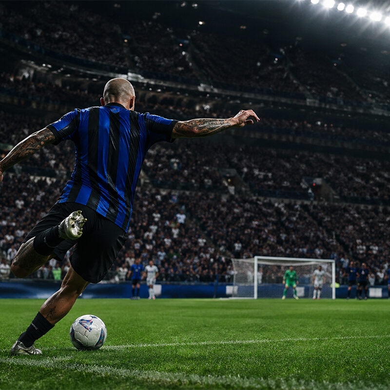 Dimarco assist record, calciatore nerazzurro di spalle batte un calcio d’angolo in uno stadio gremito