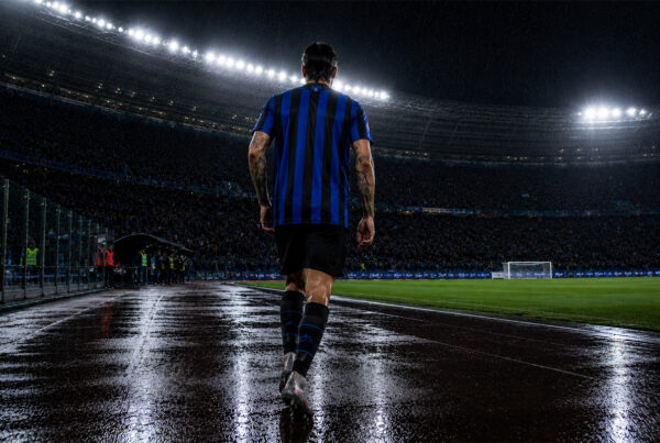 Acerbi cammina di spalle sotto la pioggia nello stadio illuminato durante la sua ultima notte con l’Inter