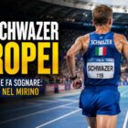 Alex Schwazer di spalle mentre corre su una pista d’atletica all’interno di uno stadio illuminato durante una grafica sportiva dedicata al possibile ritorno agli Europei di Birmingham.
