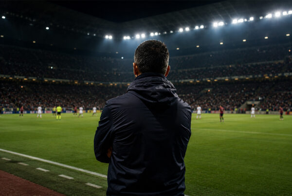 Pisacane di spalle osserva il campo durante una partita del Cagliari in uno stadio illuminato, immagine sportiva iperrealistica.