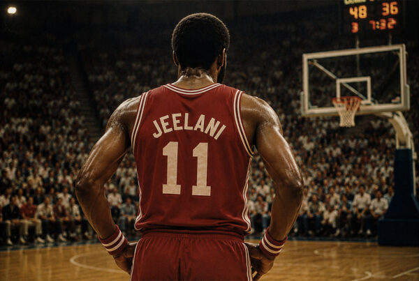 Abdul Jeelani di spalle con maglia rossa numero 11 su un campo da basket, in un'arena gremita durante una partita in stile vintage anni Ottanta.
