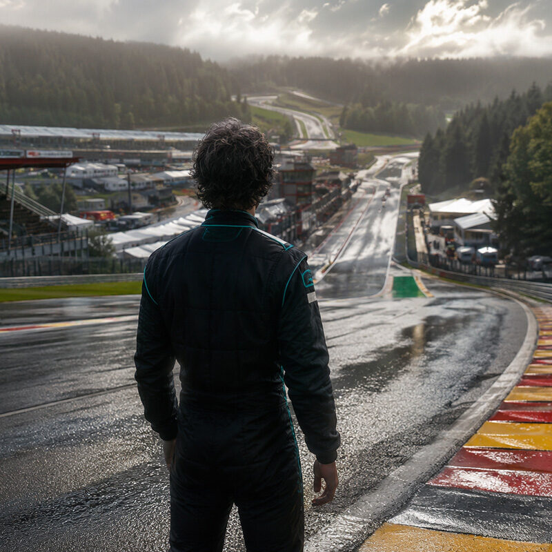 Pilota di Formula 1 di spalle sul circuito di Spa-Francorchamps prima della gara, simbolo del riscatto nella corsa di Antonelli Spa Mondiale 2026.