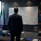 Paolo Maldini Italia mentre osserva un piano tattico all'interno del centro tecnico federale, rappresentato di spalle in un moderno ufficio sportivo con campo da calcio sullo sfondo, simbolo della nuova organizzazione della Nazionale.
