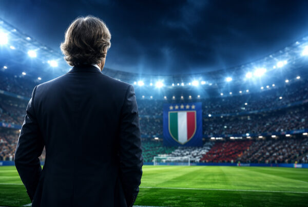 Mancini Italia: allenatore della Nazionale italiana ritratto di spalle a bordo campo mentre osserva lo stadio illuminato, simbolo dell'inizio del nuovo ciclo azzurro e delle ambizioni verso Europeo e Mondiale.