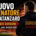 Nuovo allenatore del Catanzaro: grafica editoriale con Giorgio Gorgone di spalle in uno stadio illuminato dai colori giallorossi, titolo in evidenza e bandiera del Catanzaro sfocata sullo sfondo per annunciare l'inizio della nuova era tecnica.