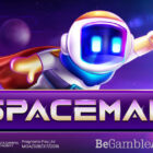 Personaggio astronauta stilizzato Spaceman su sfondo viola, con visiera luminosa blu, gesto della vittoria e logo SPACEMAN in primo piano.