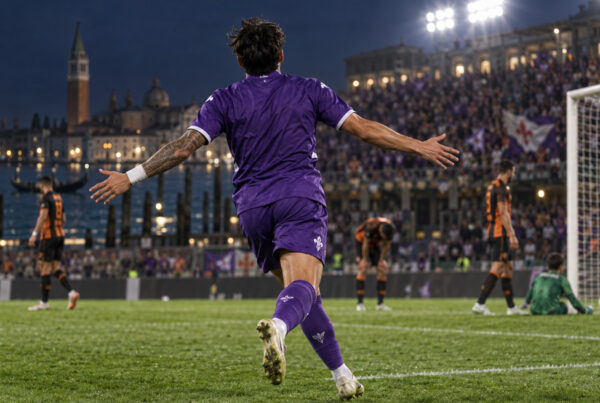 Venezia Fiorentina 2-4, calciatore viola di spalle festeggia sul campo sotto i riflettori.